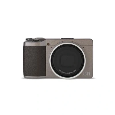 Immagine di Ricoh GR III Diary Edition, fotocamera digitale compatta, corpo grigio caldo metallizzato, impugnatura marrone scuro e anello argento naturale, sensore CMOS APS C da 24MP, obiettivo 28mmF2.8