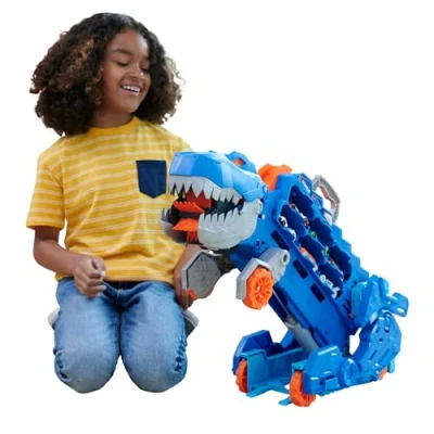 Immagine di ​Hot Wheels City &#039;Let&#039;s Race&#039; Netflix Mega Dino Trasportatore, pista da corsa che si trasforma in un T Rex, playset con luci e suoni, box per riporre 20 macchinine scala 1:64, 4+ anni, HNG50