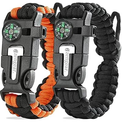 Immagine di aZengear Braccialetto sopravvivenza in paracord (coppia) │ Accendifuoco selce e acciaio, fischietto, bussola, fascia regolabile per campeggio, bushcraft, kit di emergenza (nero arancione)