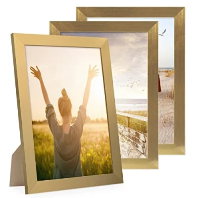 Immagine di PHOTOLINI cornici A4 21x30 cm oro legno MDF, set di 3 larghe, moderne, plexiglass infrangibile, da tavolo o parete, accessori extra per una parete dal look raffinato